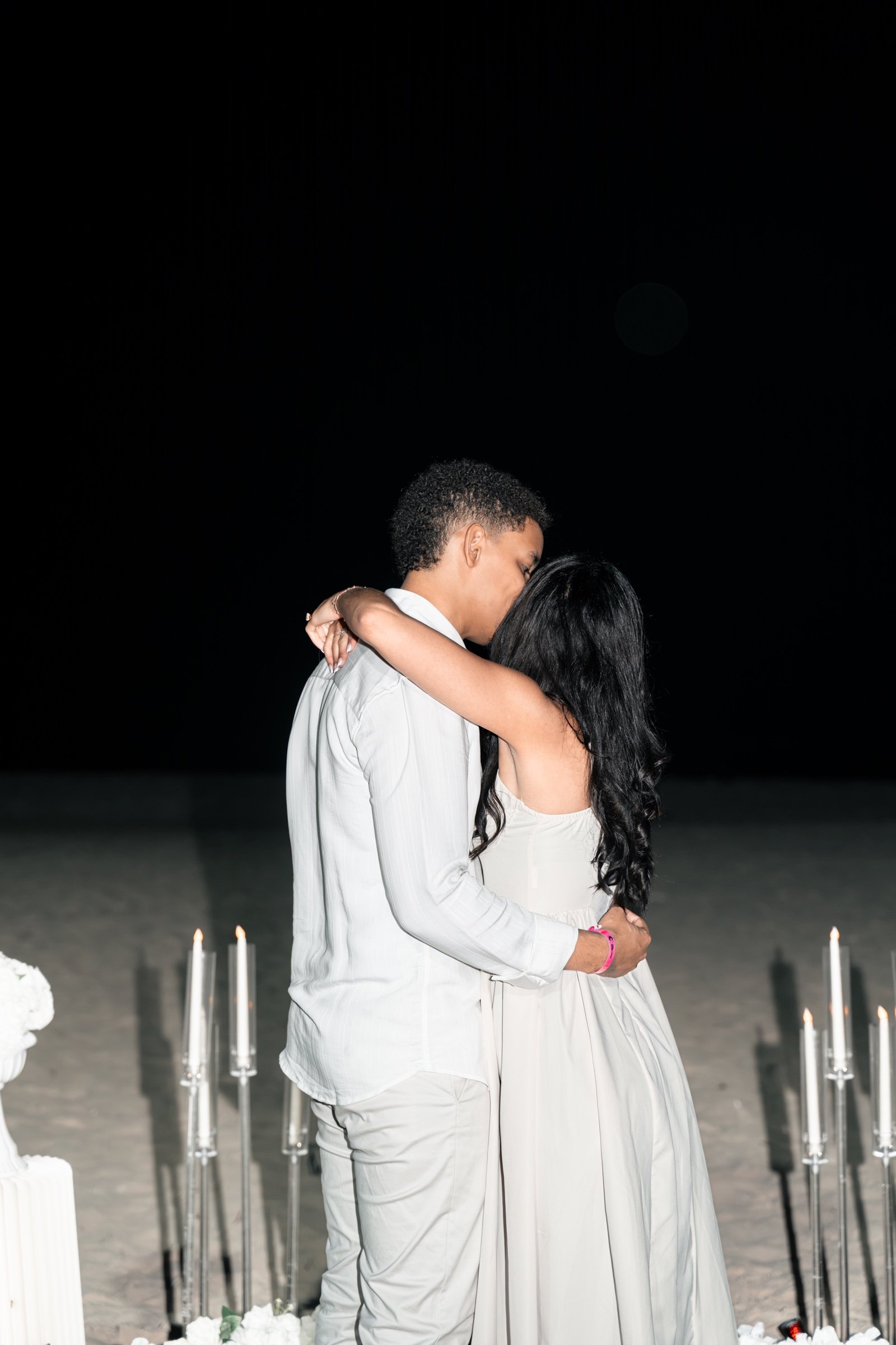 Moises y Sashalee se abrazan entre las velas.