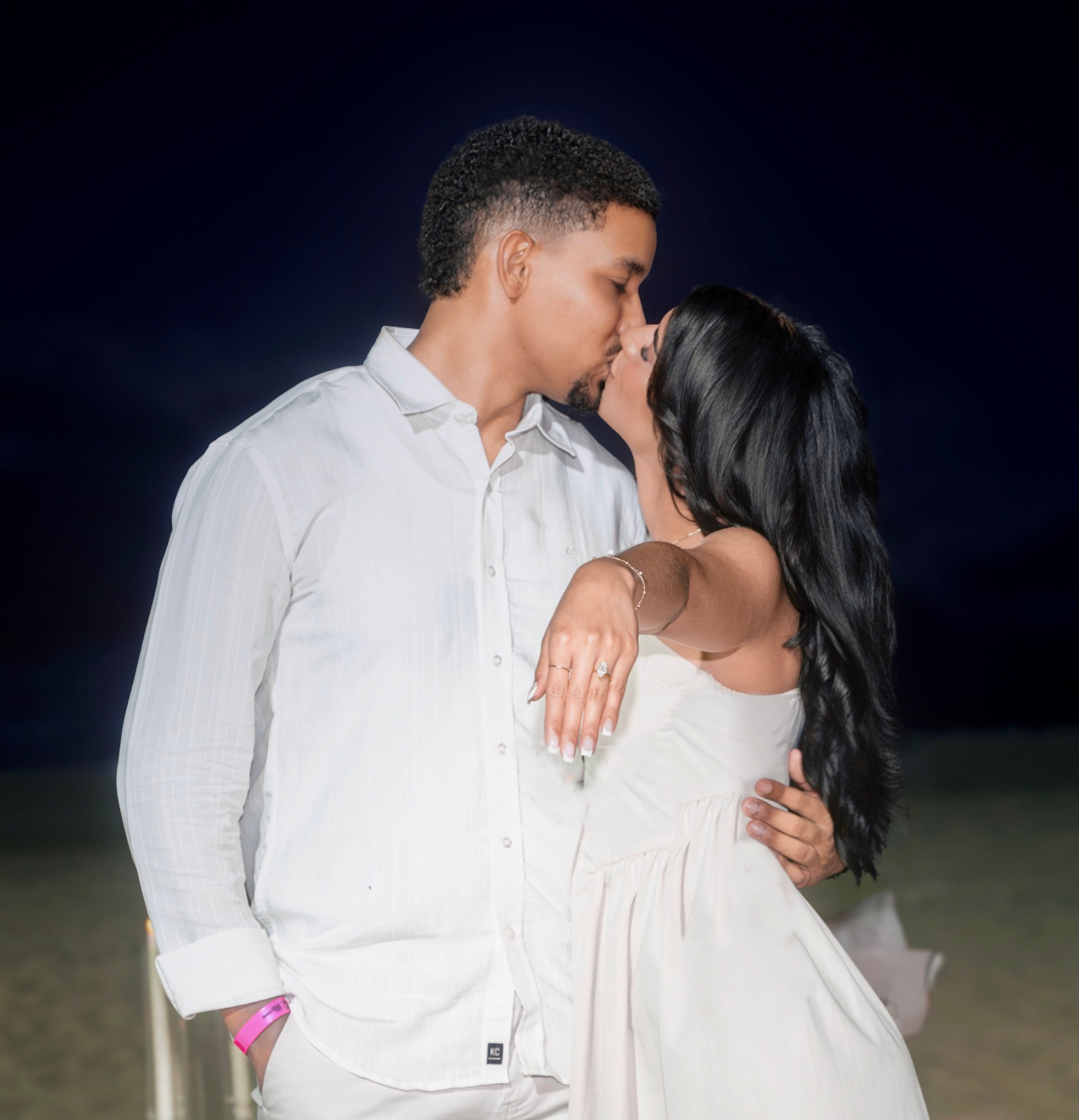 Moises y Sashalee se besan mientras ella muestra su anillo de compromiso.
